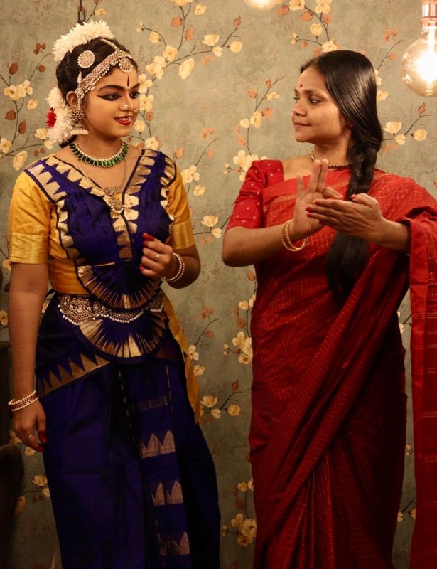 A teacher showing a hand gesture to her student