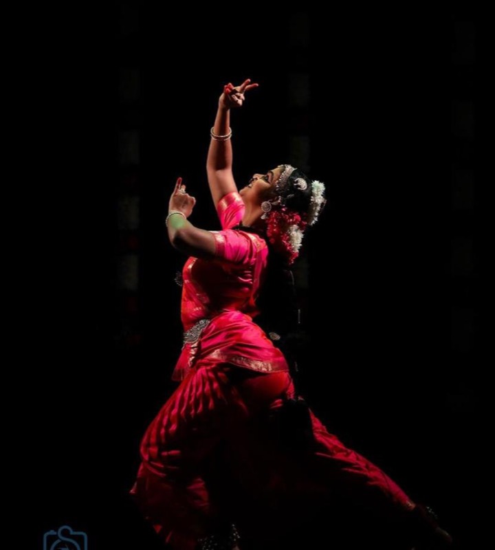 Dancer in red silhouetted against black