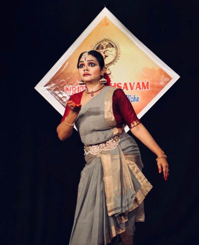 Teacher performing in front of a Nataraja backdrop