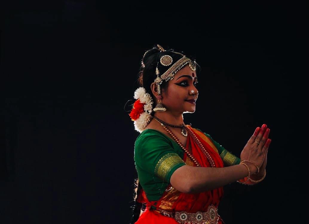 Teacher in namaskaram on a dark stage